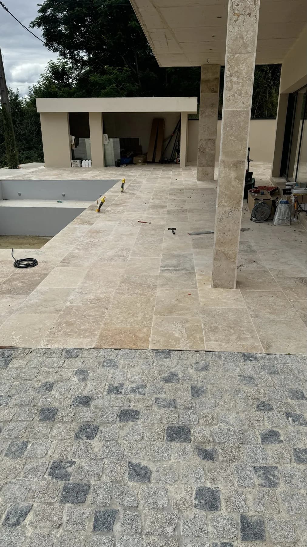 Travertin et pavés de granit, terrasse couverte